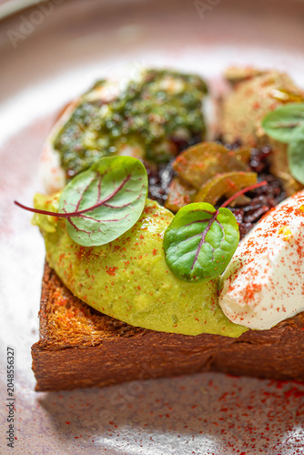 Crispy toast topped with poached eggs creamy sauce and fresh herbs served as elegant brunch dish