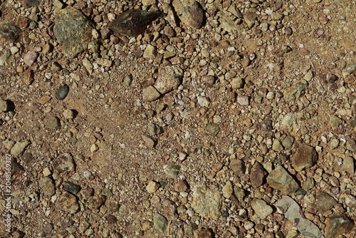Photography A dry soil surface covered with gravel, small rocks, and coarse sand in brown, cream, and gray colors