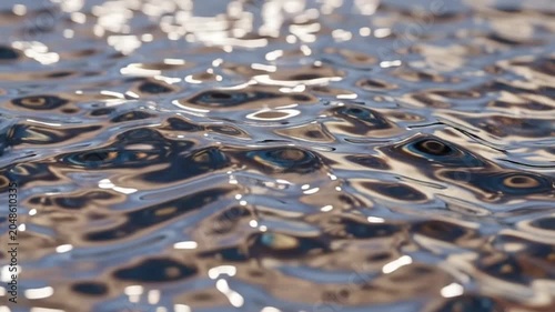 Abstract Water Surface with Ripples and Reflections in Sunlight.