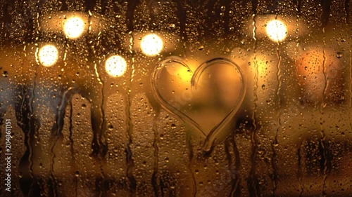 Heart Drawn on Steamy Window with Bokeh Lights Background.