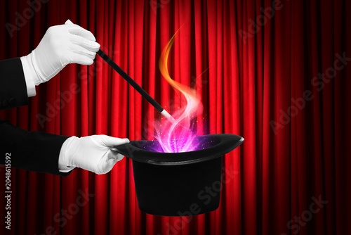 Fotografi Magician performing trick on stage with red curtains, closeup