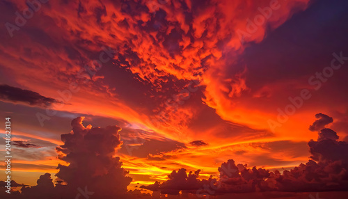 Dramatic sunset sky with fiery orange and red clouds, high contrast, breathtaking natural spectacle, perfect for backdrop or atmospheric scenes