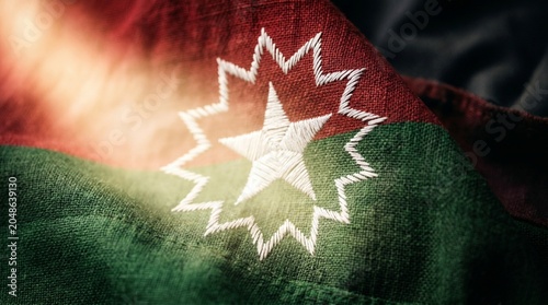 Close up of embroidered star on Juneteenth flag with red, green, and black colors.