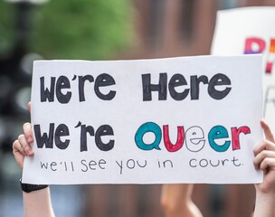 We’re here, we’re queer, we’ll see you in court sign 