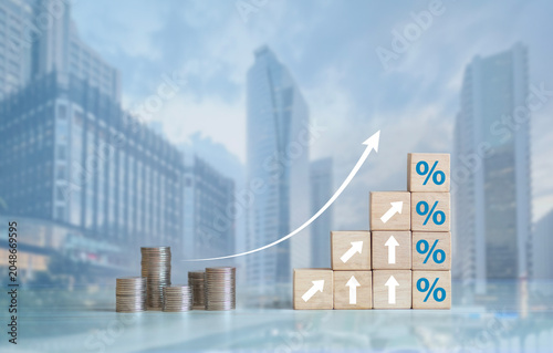 Fotografie The concept of financial interest rates and mortgage interest rates is represented by wooden blocks with percentage symbols and upward-pointing arrows