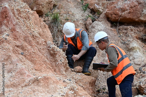 Geologists conducting field inspection and geological survey at an excavation site. Professionals analyzing soil, rock formations and subsurface conditions for mining, construction and exploration pro