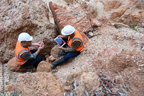 Geologists conducting field inspection and geological survey at an excavation site. Professionals analyzing soil, rock formations and subsurface conditions for mining, construction and exploration pro