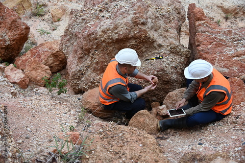 Geologists conducting field inspection and geological survey at an excavation site. Professionals analyzing soil, rock formations and subsurface conditions for mining, construction and exploration pro