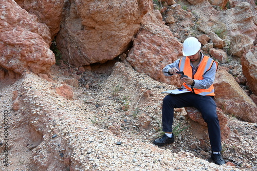 Konstfotografi Geologists conducting field inspection and geological survey at an excavation site