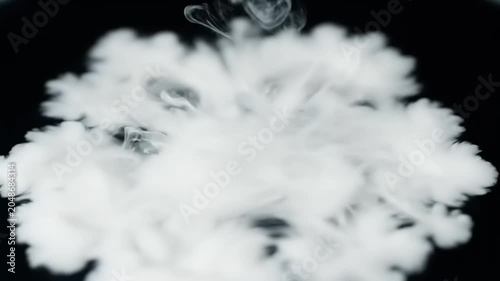 Smoke rises quickly from a pile in a dark environment