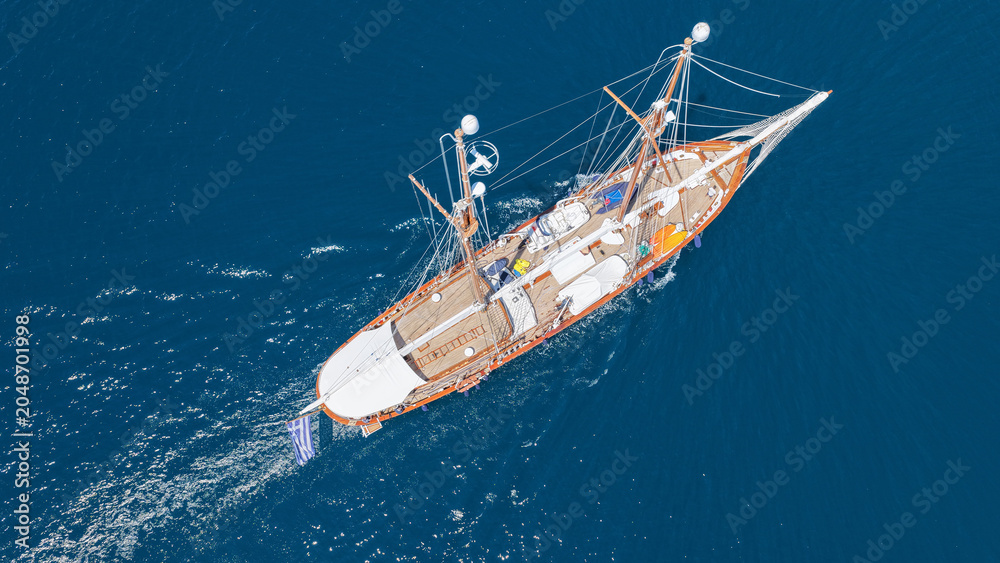 Naklejka premium Aerial drone top down photo of classic wooden double mast sailing ship cruising in open ocean sea