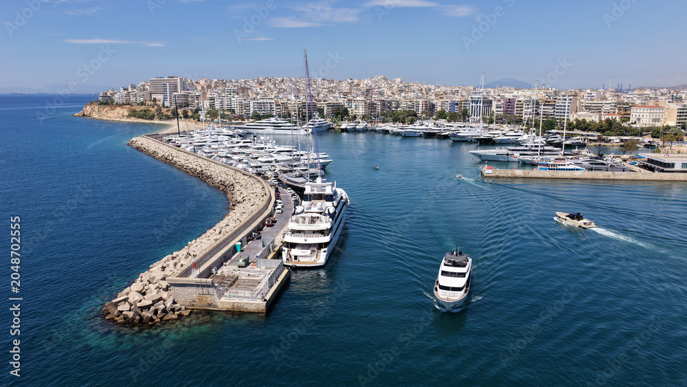 Fototapeta premium Aerial drone photo of small yacht cruising in low speed near marina and port of Zea or Pasalimani, Piraeus, Attica, Greece