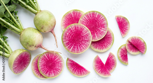 Fresh whole and sliced watermelon radish on white background