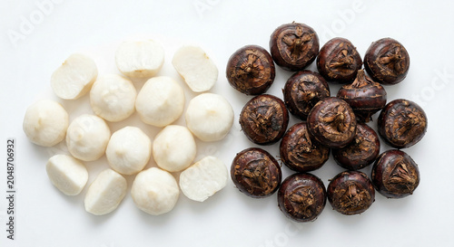 Fresh whole and peeled water chestnuts on white background