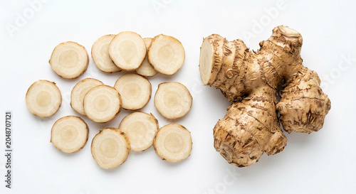 Fresh galangal root and slices on white background
