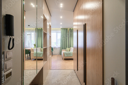 Принти на полотні Modern hallway with mirrored and wooden wardrobes, leading to a cozy living area