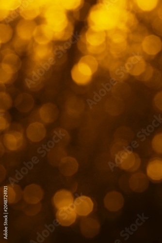 Abstract golden bokeh lights illuminating a dark background creating a warm festive atmosphere