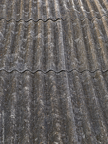 Canvastavla Weathered and deteriorating corrugated fiber cement roof, displaying a worn out