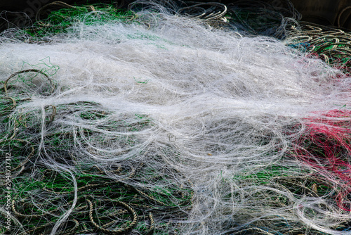 Texture of colorful tangled fishing nets on the harbor dock