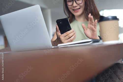 Bild auf Leinwand Young asian woman smiling during using smartphone for video call, online working