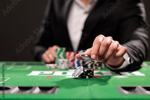 A man plays in a casino. opening cards to raise bets. Against the background of chips. Poker victory