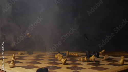 Chess pieces drop onto a chessboard - conceptual as if ready for war