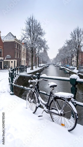 Snowy street with parked bicycles and houses.