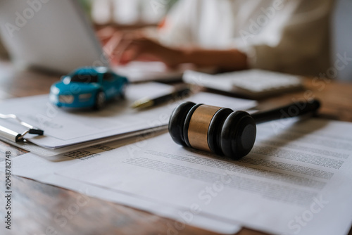 Fotografie A judge’s gavel stands beside a model car and legal documents, symbolizing auto insurance claims, traffic accidents, liability disputes, compensation, and legal justice