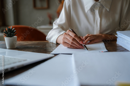 A professional reviews and organizes stacks of business documents, symbolizing paperwork management, administration, auditing, compliance, and office productivity.