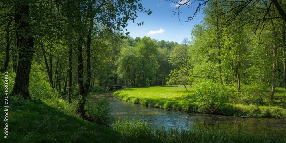 Obraz premium Peaceful countryside scene featuring lush woodland and curving river in summer
