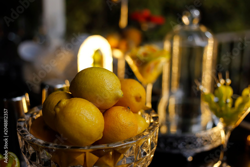 Crystal bowl filled with fresh yellow lemons for table and bar decoration
