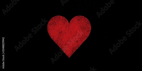 Sharp red heart silhouette framed boldly against a dark black grainy background with copy space