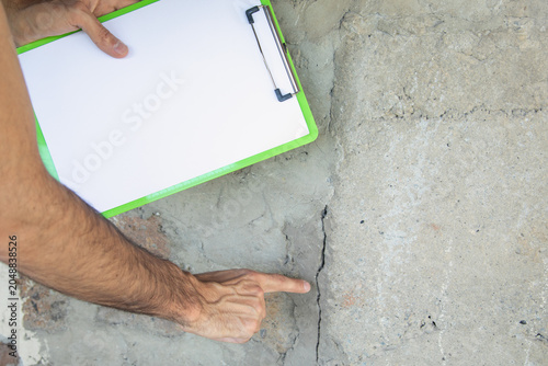 Photos Man checking a cracked wall after earthquake.