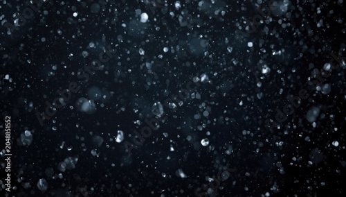 Winter themed composition featuring isolated white snow and snowflakes on dark background