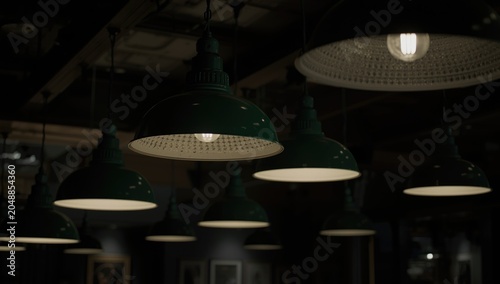 Interior setting featuring multiple green hanging lamps providing ambient light