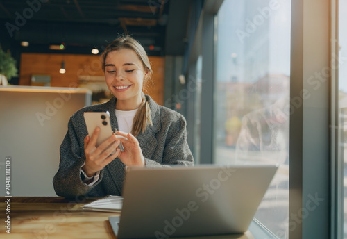 Obraz na plátně Happy young Caucasian female entrepreneur working in cafe with natural window li