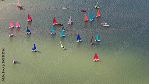 Dinghy race shows dinghies sailing on a lake, England