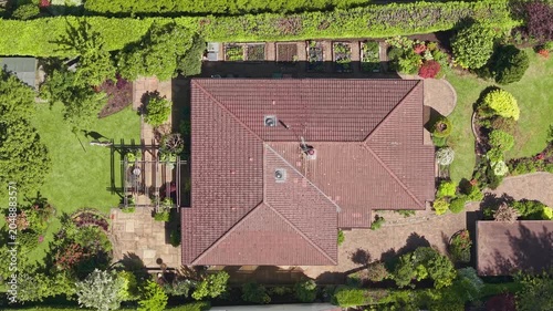 Overhead view of bungalow house roof with landscaped garden in residential property, England