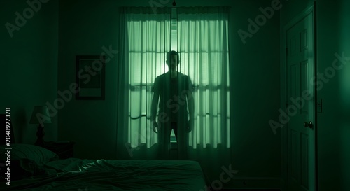 Man standing behind curtains in a dark bedroom with green moody lighting, horror concept