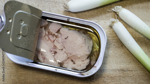 Open can of seafood cod liver on wooden board