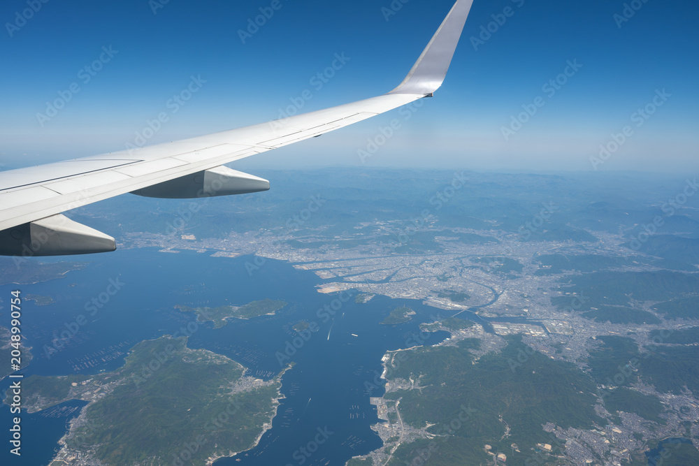 Fototapeta premium Hiroshima Cityscape and Hiroshima Bay Viewed from Airplane Window, Hiroshima, Japan