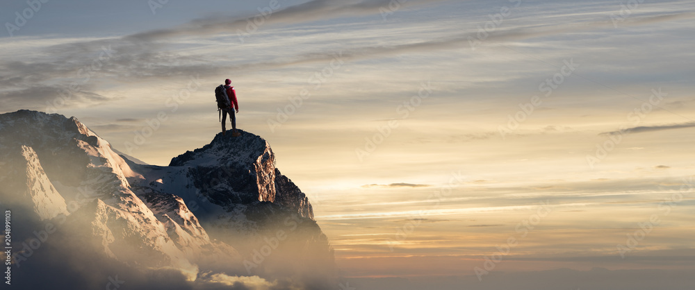 Obraz premium Wanderer auf einem Bergipfel schaut in den Sonnenuntergang