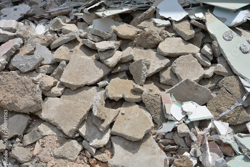 A high angle view of shattered concrete pieces ceramic tiles and drywall fragments from building demolition.