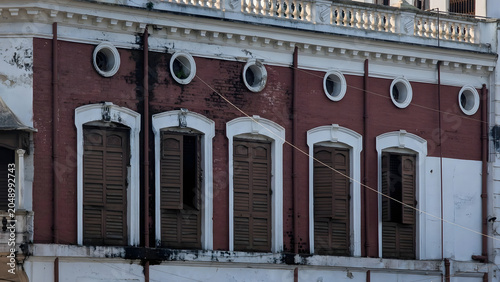 Quadro em tela Abandoned red brick building with boarded arched windows in urban decay setting