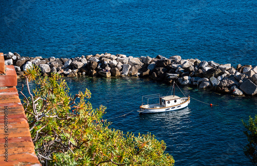 CINQUE TERRE, ITALY – A fishing boat rests near the rocky breakwater of Manarola in Cinque Terre, where the small harbor continues the maritime traditions of this UNESCO coastal village.