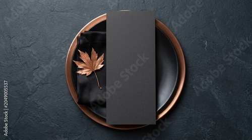 Elegant dark table setting with blank menu and autumn leaf for dining or event