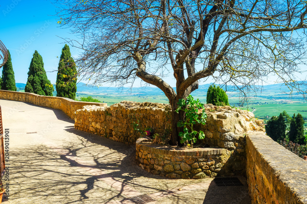 Naklejka premium Panoramic view of the hills and countryside surrounding the village of Pienza (Tuscany village, Italy) seen from its medieval fortified walls, during early summertime.