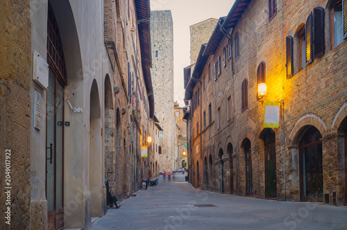 View of and old alley at the dusk in San Gimignano, medieval village of Tuscany (Province of Siena, Italy); is world famous for its renaissance monuments and white wine production (named 