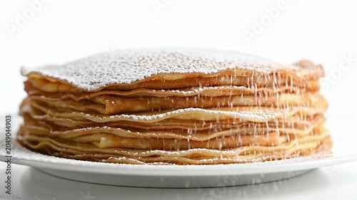 Stack of fresh homemade pancakes on white plate.