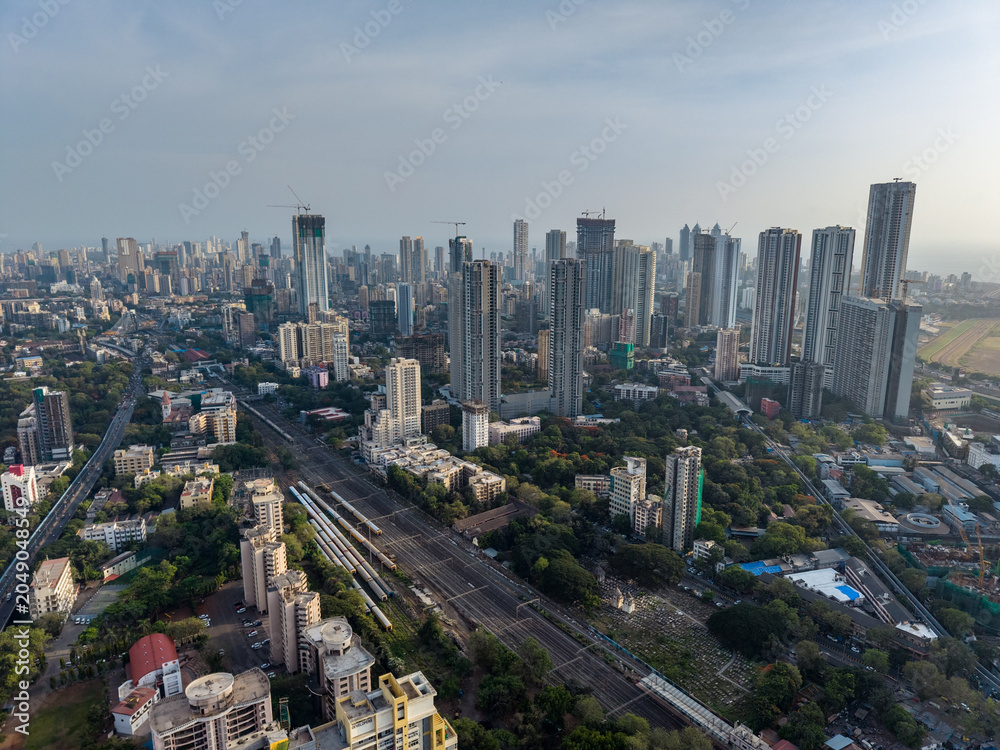Naklejka premium Mumbai skyline and railway corridor aerial drone view India Aerial view of Mumbai cityscape with railway tracks and skyscrapers
